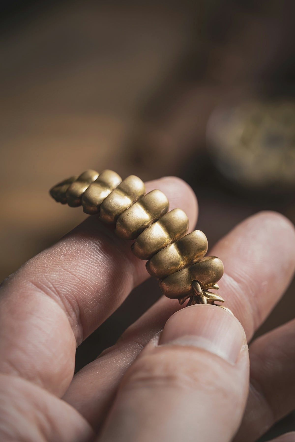 a person holding a tiny gold object in their hand