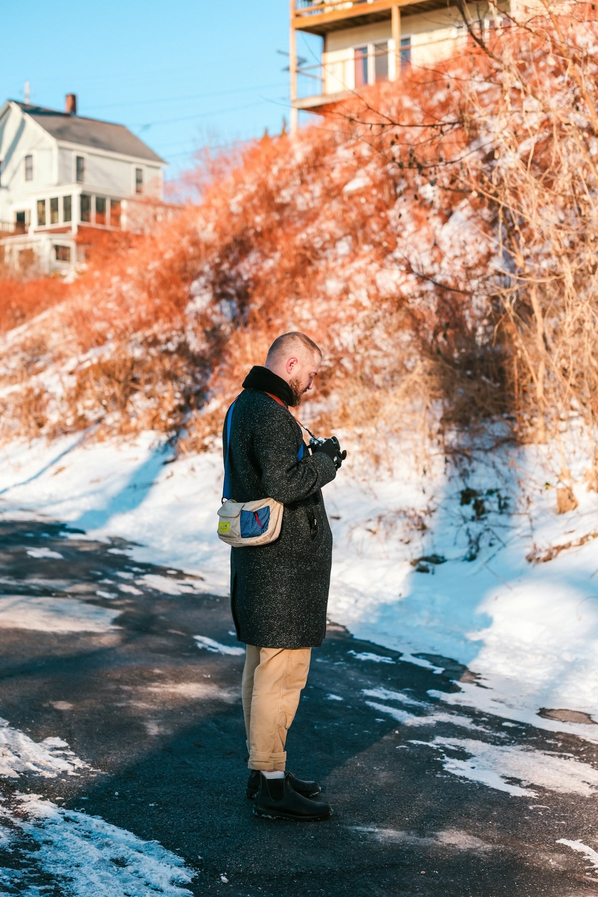 A man standing on the side of a road in the snow