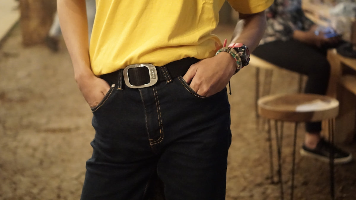 man in yellow polo shirt and black denim jeans