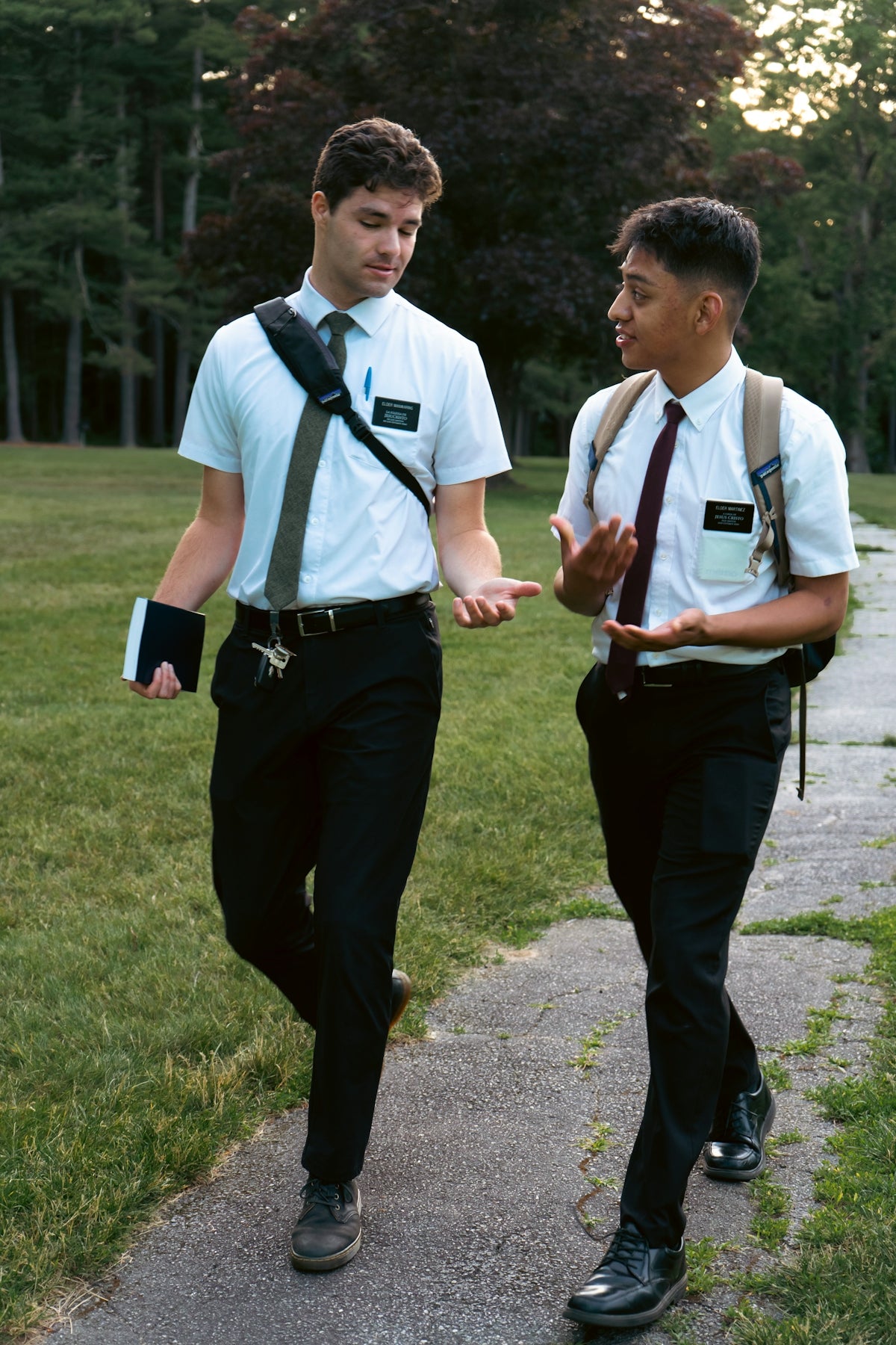 Two young men in white shirts and ties walking.