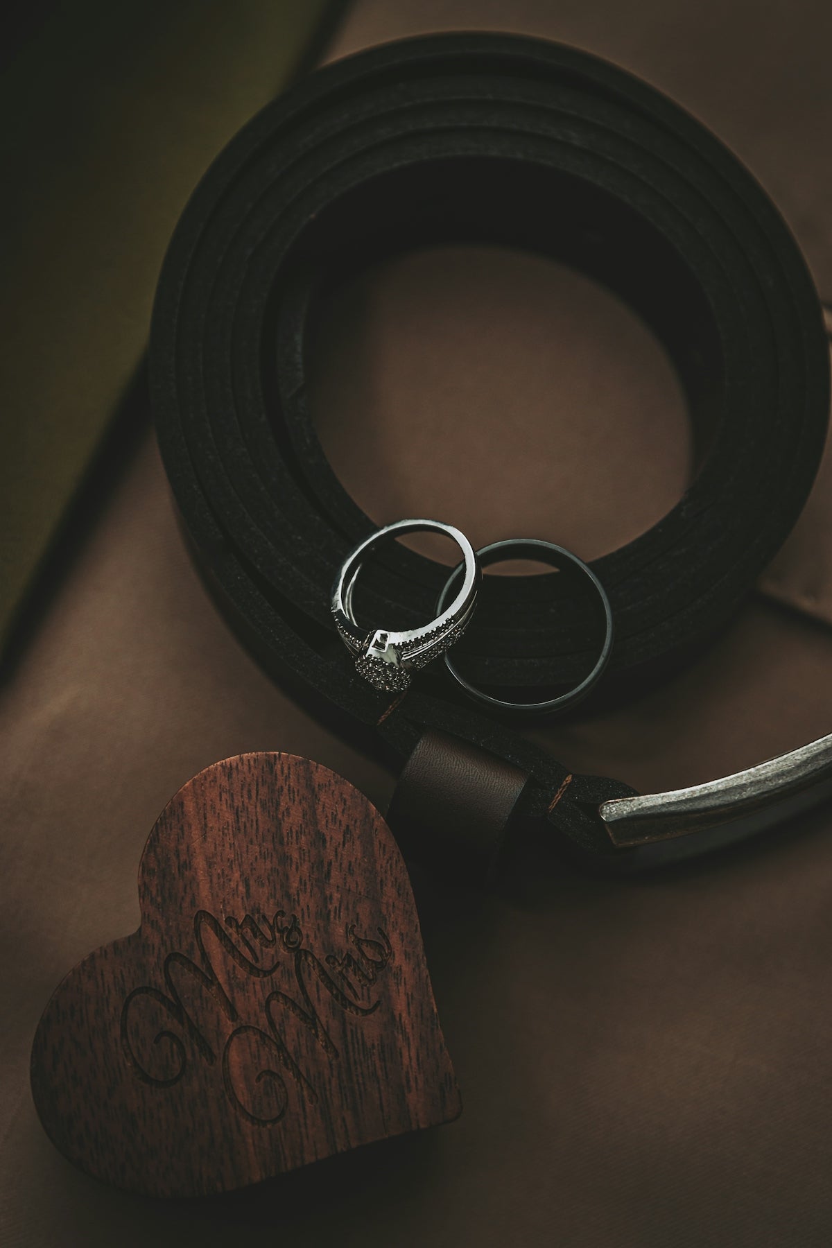 Wedding rings on a leather surface with wooden box