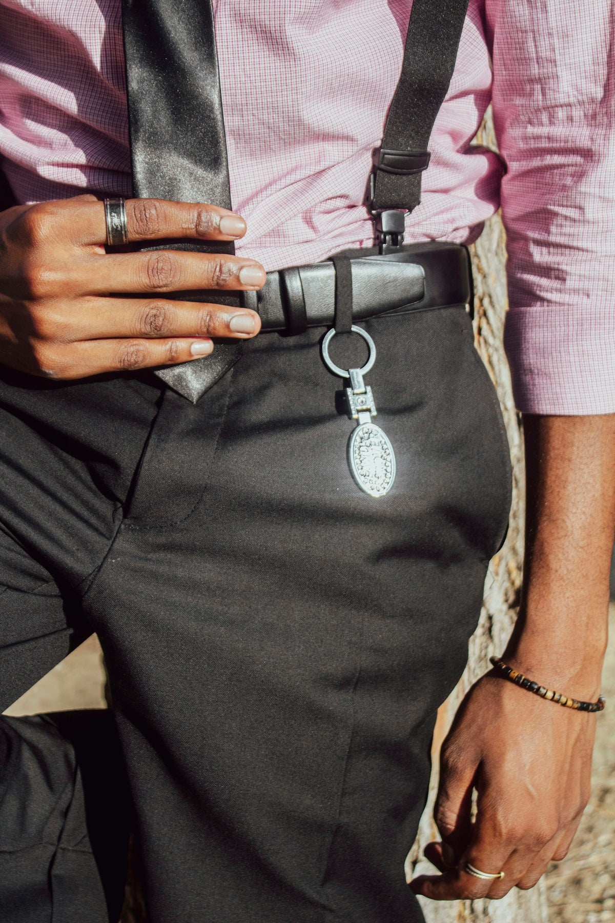 Man in pink shirt, black pants, and suspenders
