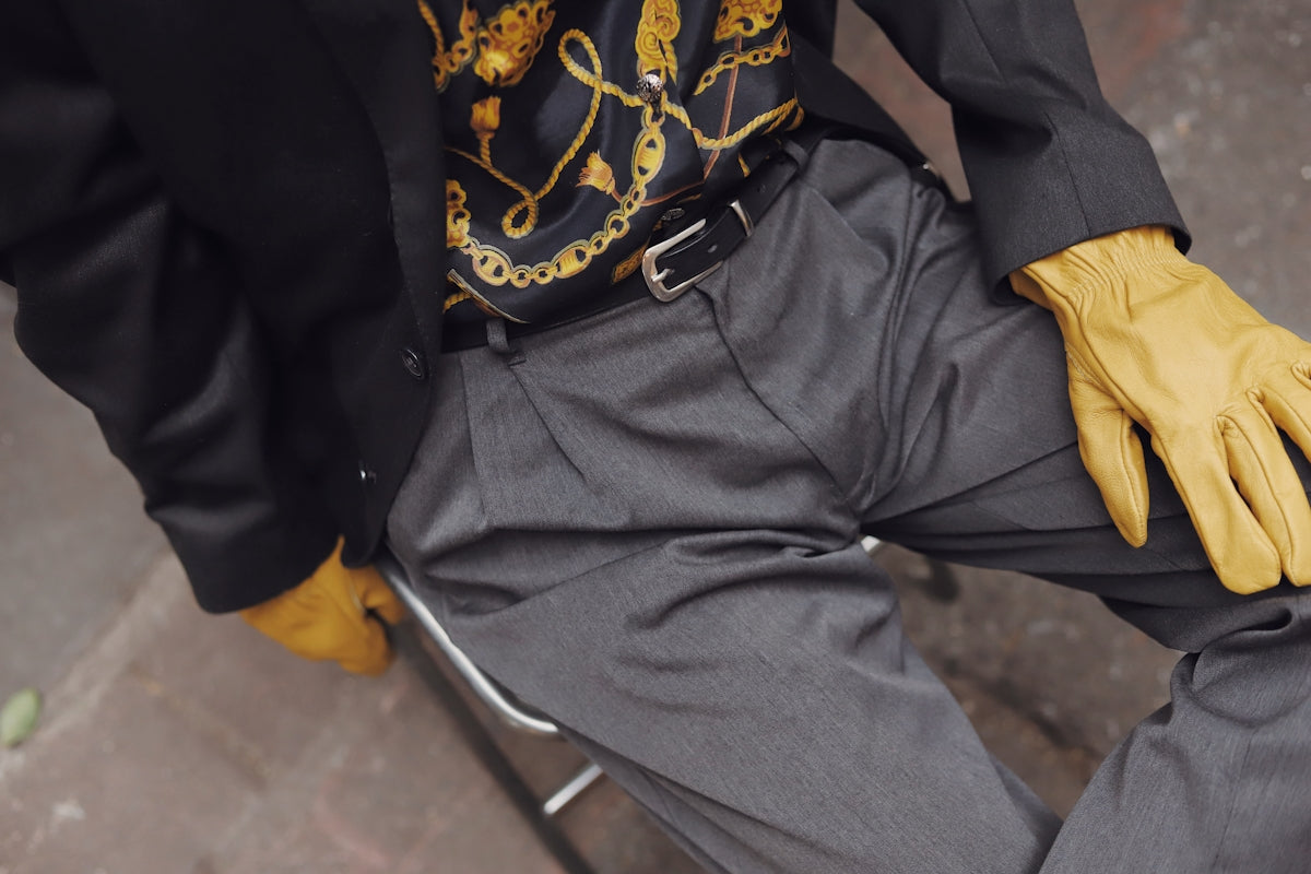 Man in suit with yellow gloves sitting down